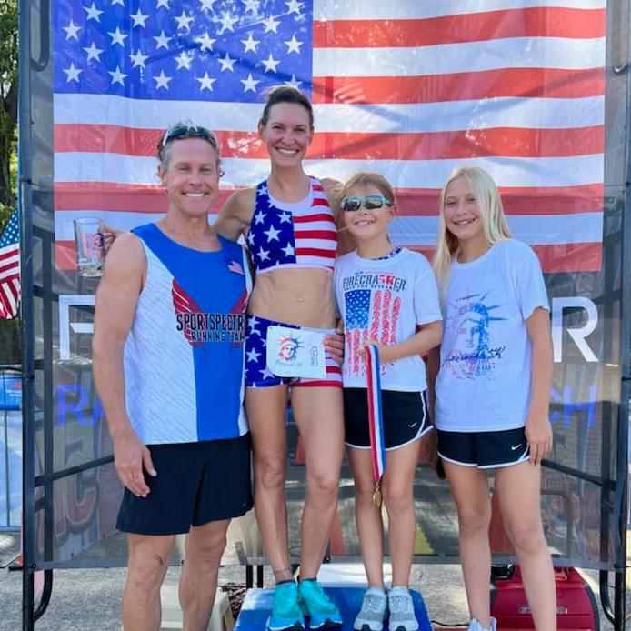 Family of four posing on race winner's blocks.