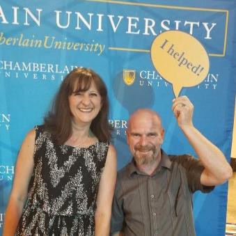 Woman and man standing in front of a Chamberlain University banner
