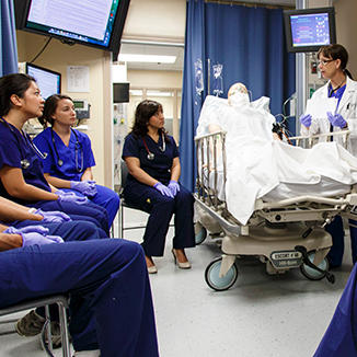 Instructor demonstrating to nursing students in a simulation lab