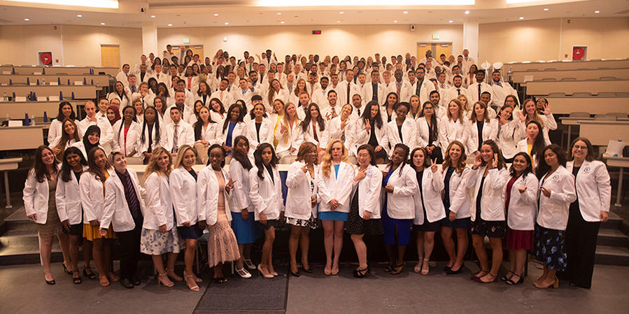 Classroom filled with students wearing white coats
