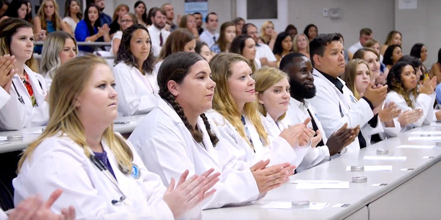 RUSVM students in a classroom wearing white coats
