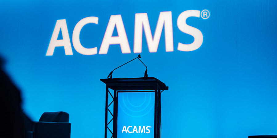 Blue-lit empty ACAMS podium at a conference