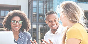 A diverse group of three young people studying in the city.