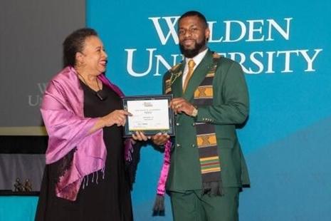 Chima Onwuka accepting a certificate from Walden University