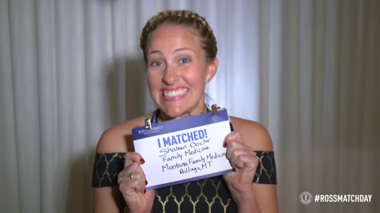 woman smiles holding sign that says i matched