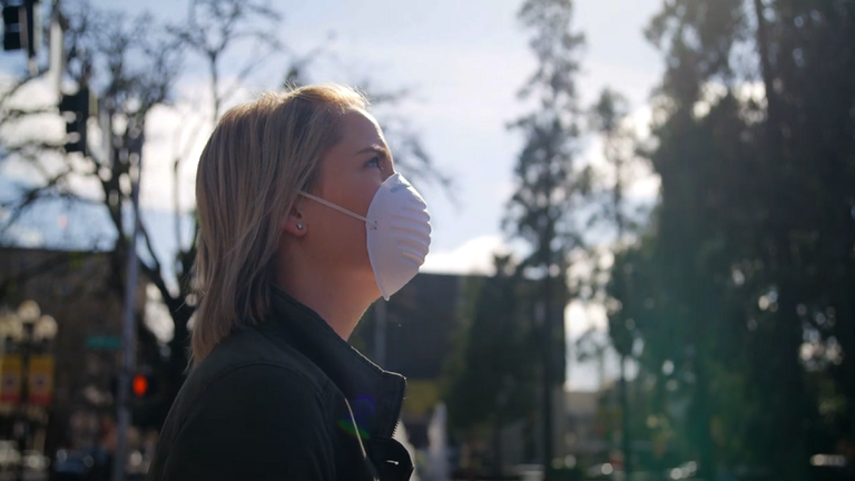 woman standing outside wearing a face mask