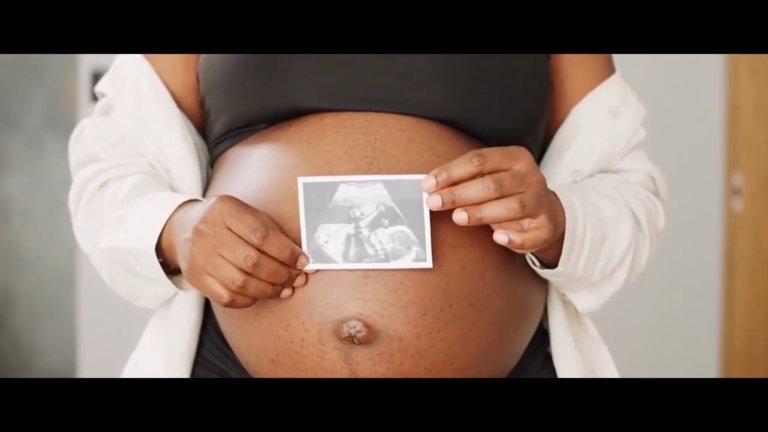 Woman holding ultrasound phot in front of her belly