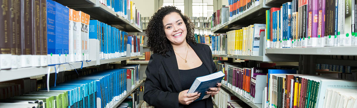 Student in a library holding a book