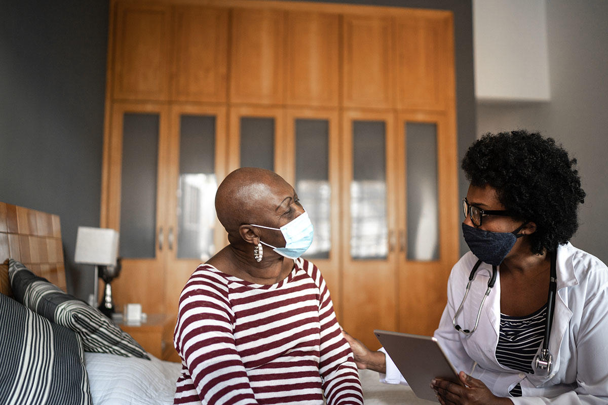 Black doctor and patient during a check up with masks