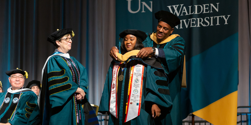 "Doctoral graduate being hooded at Walden University commencement"