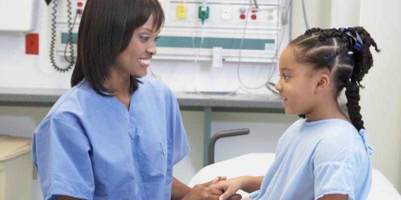 Black female doctor with Black pediatric patient
