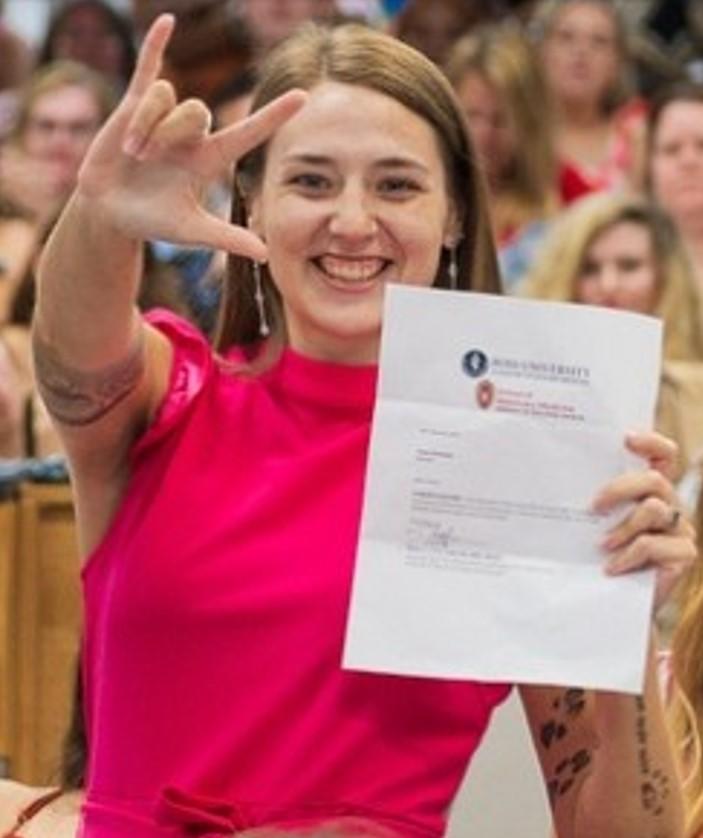 Grace Pechman signing "I love you" in American Sign Language