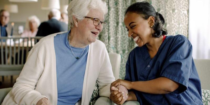 a nurse and elderly patient holding hands