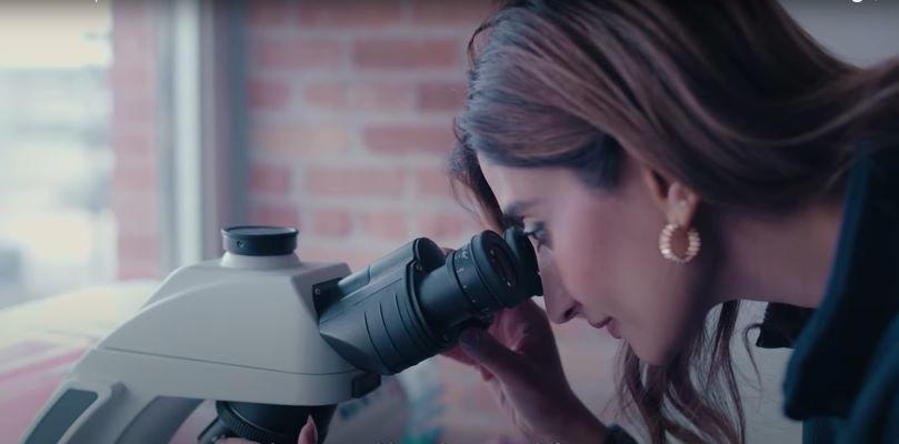 Dr. Roohi Jeelani looking through a microscope