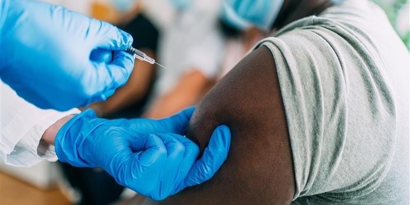 a doctor administering a vaccine to a Black patient