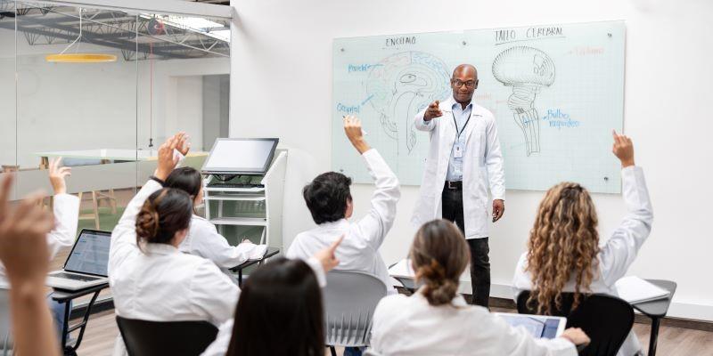 a medical school classroom with students raising their hands