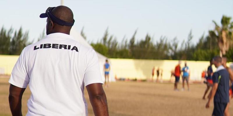 Sayon Cooper wearing a Team Liberia coach shirt