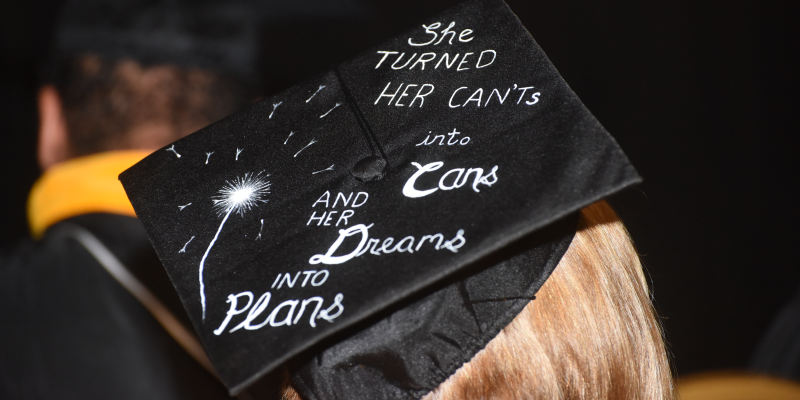 a graduation regalia cap with the text "she turned her cannots into cans and her dreams into plans"
