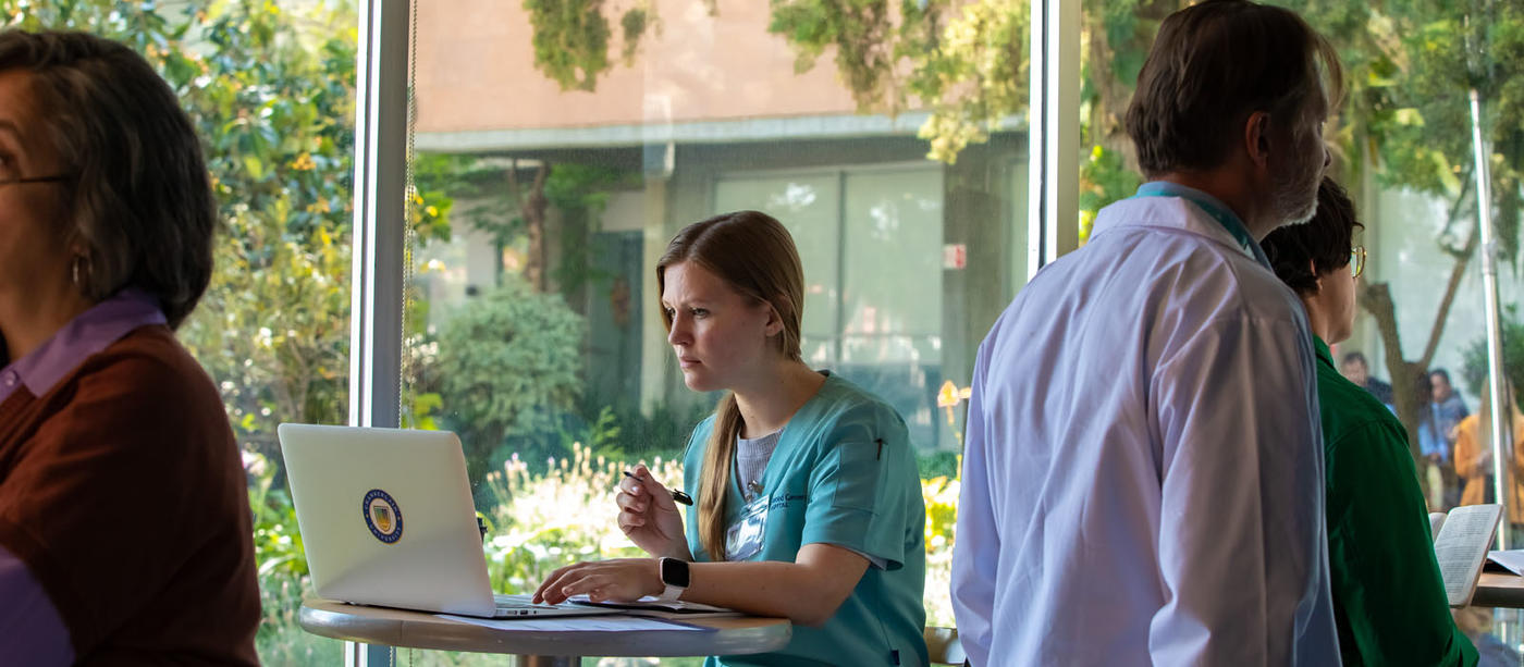 Woman in green scrubs on laptop