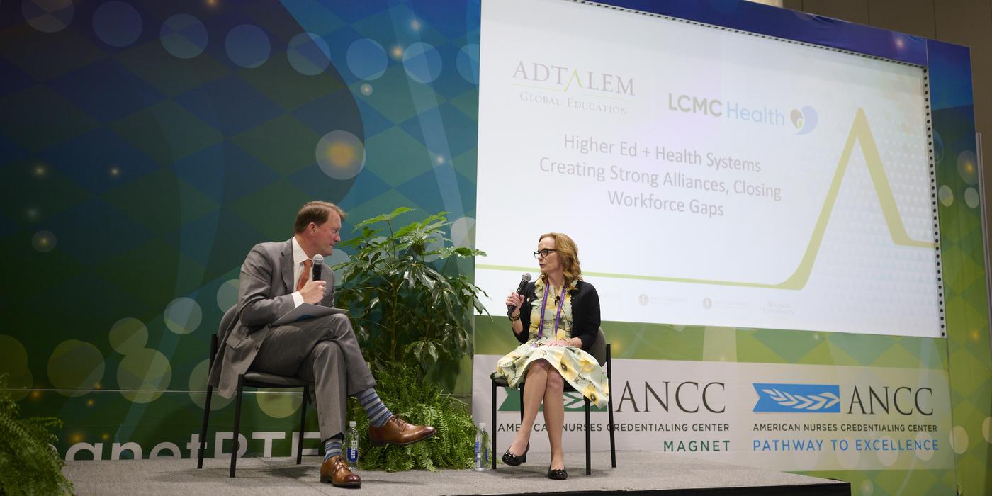 Dr. Karen Cox and Greg Feirn speaking on stage