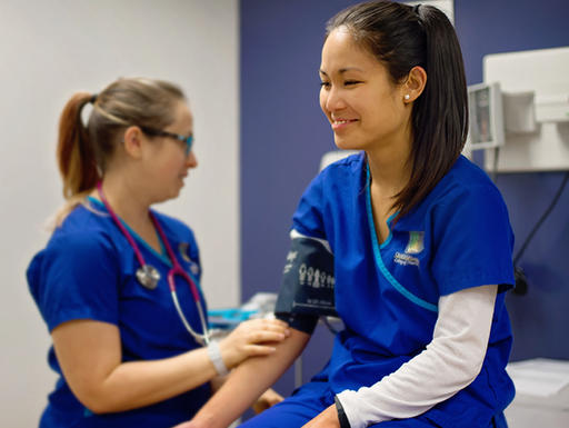 Medical student practicing taking vitals from another medical student