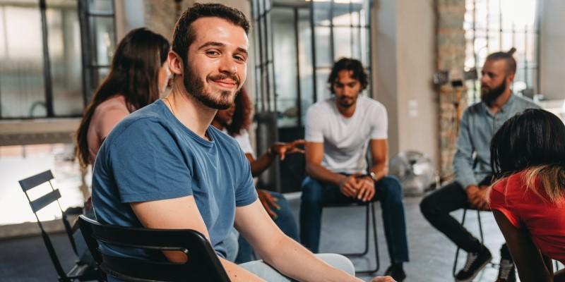 Man looking at camera during group meeting