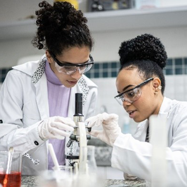 Two women in lab coats doing research