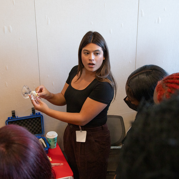 Woman making medicanl demonstration to group.