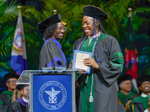 Two graduates in regalia at a graduation