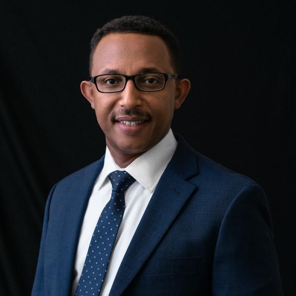 A man, Tewodros Tedla, posing in blue suit