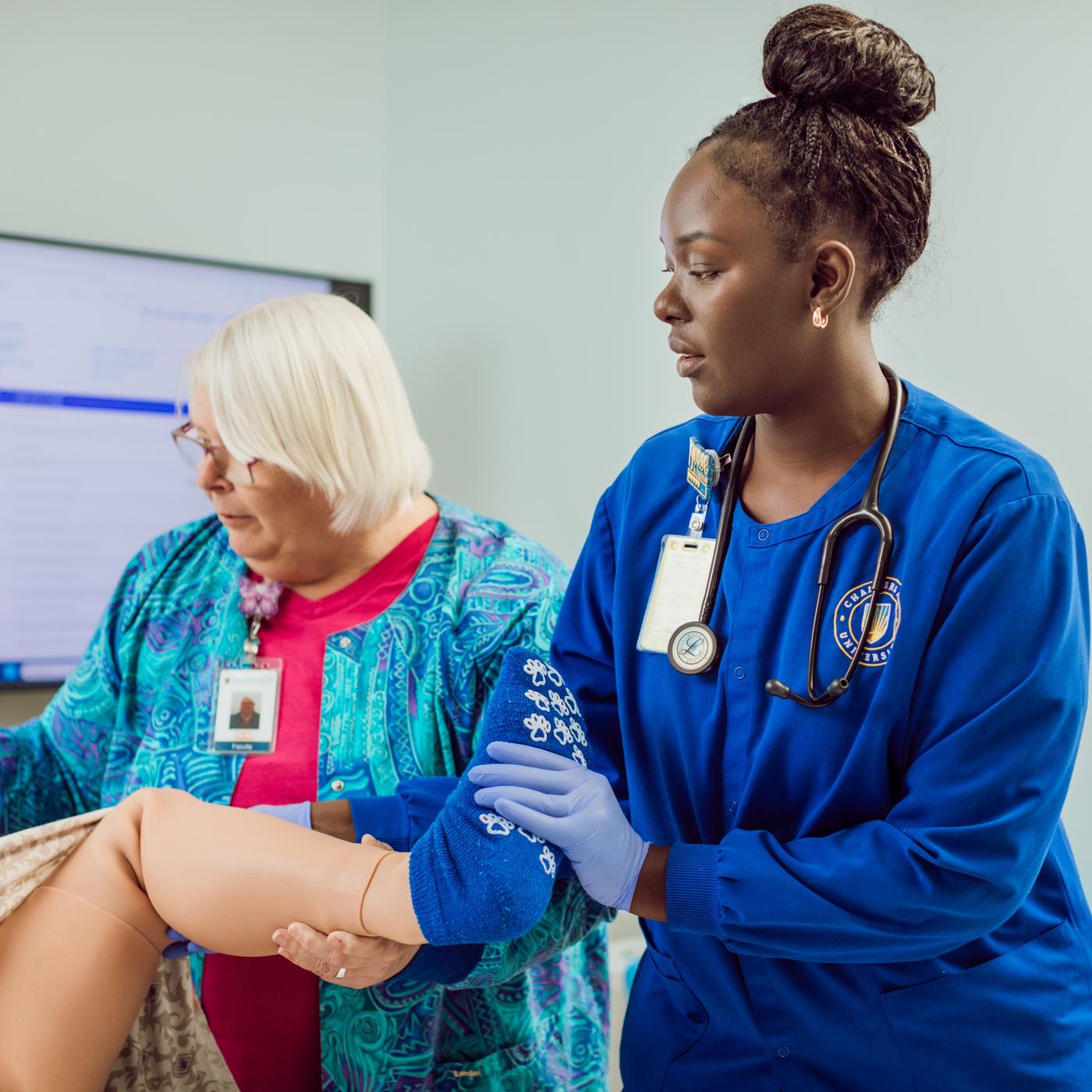 Marilyn Johnson working with an instructor on the simulation patient