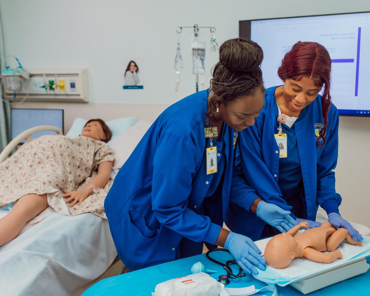 Marilyn Johnson and another student practicing with the newborn model