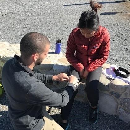 Man performing first aid on woman's knee.
