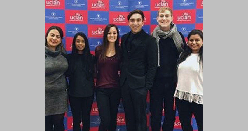 Students posing in front of a backdrop