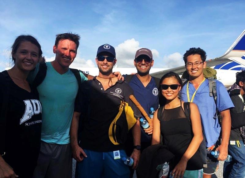 group posing in front of a plane