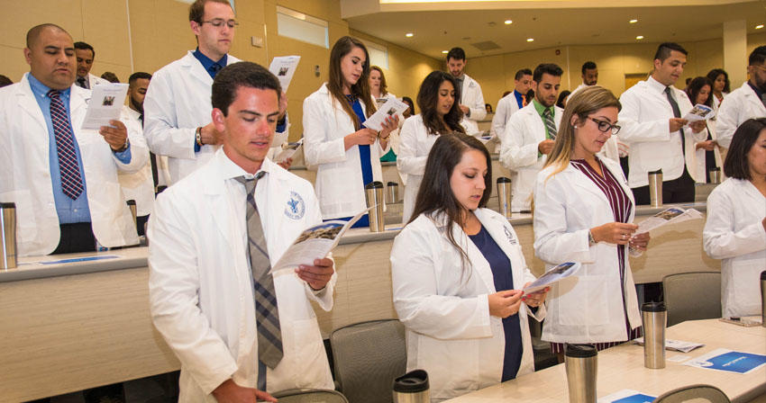 students in a classroom wearing white coats