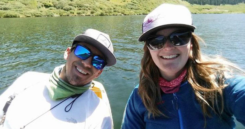 two people posing in front of a river