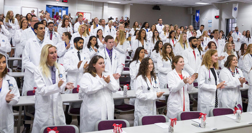 students in a classroom wearing white coats