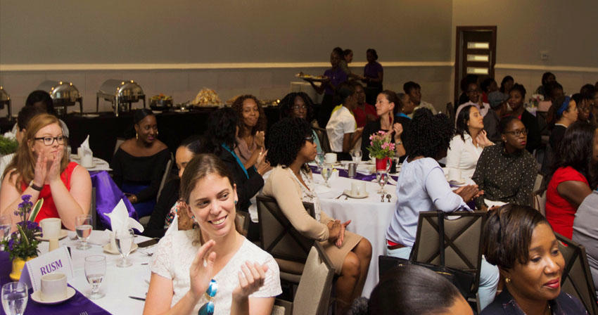 audience seated at tables applauding