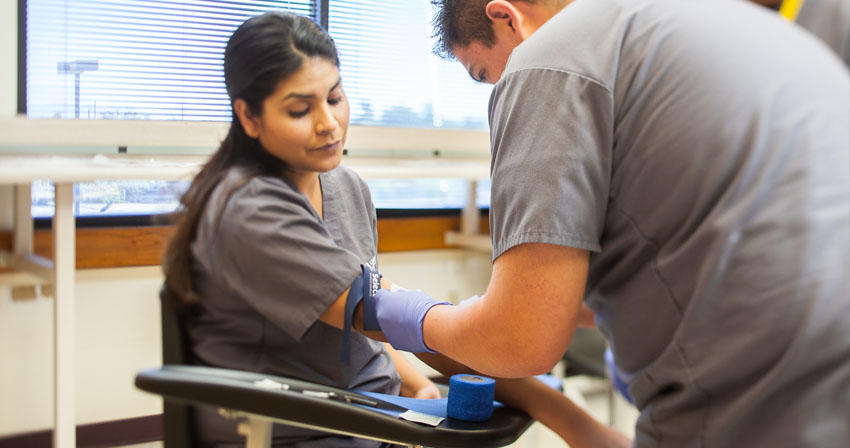 student taking another student's blood pressure