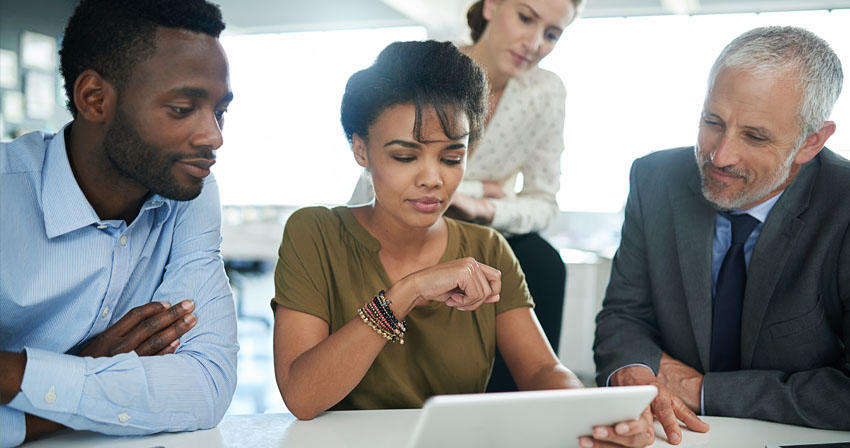 business professionals reviewing a tablet
